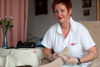 Pflegerin zieht einem Patienten einen Thrombosestrumpf an